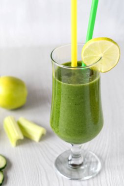 Bir bardak beyaz ahşap zemin üzerine yeşil sebze smoothies