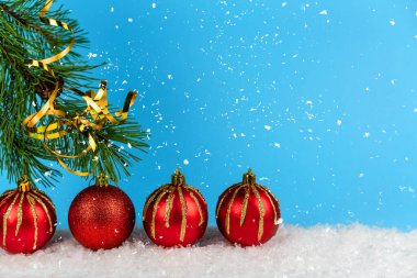 Noel arkaplanı, ladin dalı, bir grup güzel oyuncak, Noel baloları, fener ışıkları ve yağan karlarla dolu mavi renkli bir arka plan. Mutlu Noeller ve yeni yılınız kutlu olsun..