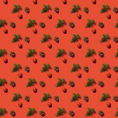 Spruce dalı, konisi ve kırmızı arka planda Noel oyuncağı olan kusursuz bir yaratıcılık örneği. Kumaş ve ambalaj kağıdı üzerine baskı kavramı..