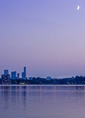 Mavi saatte Kralingen Park şehrin doğu bölümünde gölde yakalanan hilal ile şehir merkezi Rotterdam, Hollanda.