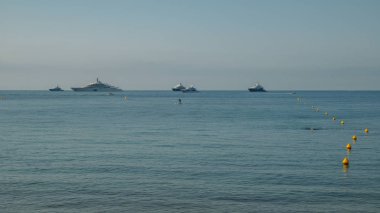 Yatılı bir sakinlik içinde kürek ve Fransız Rivierası'nda, Akdeniz'de lüks yatların içinde belgili tanımlık geçmiş ile mavi