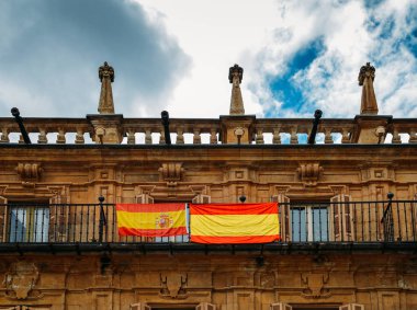 Ünlü ve tarihi Plaza Mayor Salamanca, Castilla y Leon, İspanya - Unesco Dünya Mirası üzerinde bir binanın balkonunda İspanyol bayrakları