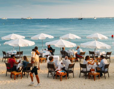 Çiftler, Juan les Pins, Cote dazur, Fransa Fransız Rivierası tatil beldesi sahilinde lüks bir restoranda içki ve mezeler var