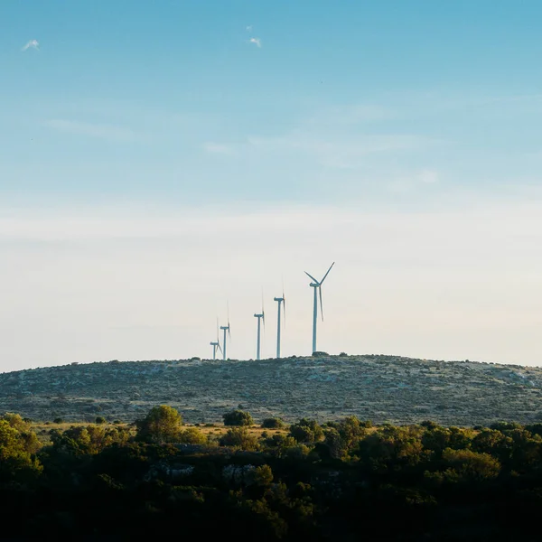 Концепція екологічної енергетики. вітрова турбіна на пагорбі з заходом сонця — стокове фото