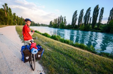 Adam dağ Mantova Veneto, İtalya gün batımında doğru Mincio Nehri boyunca bir çakıl yol bisikleti