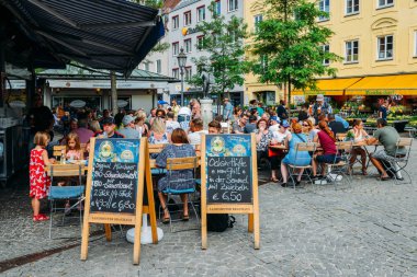 Yerli halk ve turistler bira ve Viktualienmarkt bir açık hava bira bahçesinde Münih, Almanya'nın tarihi merkezinde gıda zevk