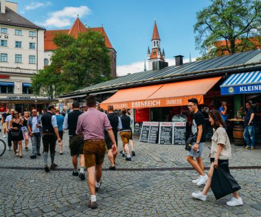 Traditionally dressed Bavarian men at an open air beer garden in Viktualienmarkt in the historic centre of Munich, Germany