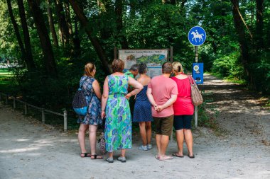 Turistler bak bir harita İngilizce Bahçe, Münih, Almanya'nın merkezinde ünlü bir park