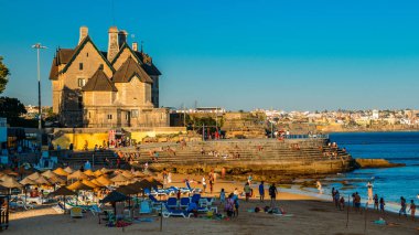 Yaz boyunca Lizbon, Portekiz yakınlarındaki Cascais 'de kalabalık kumlu plajlar vardı. Bu sahil Praia da Conceicao olarak bilinir.