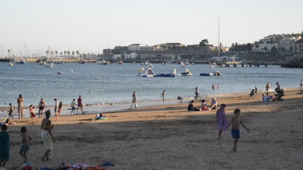 Plage de sable bondée à Cascais près de Lisbonne, Portugal pendant l'été. Cette plage est connue comme Praia da Conceicao — Video