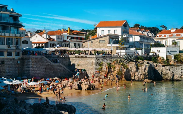 Praia da Rainha kumsalda güneşlenme insanlar. Cascais ünlü ve popüler yaz tatili Portekizce ve yabancı turistler için spot olduğunu — Stok fotoğraf