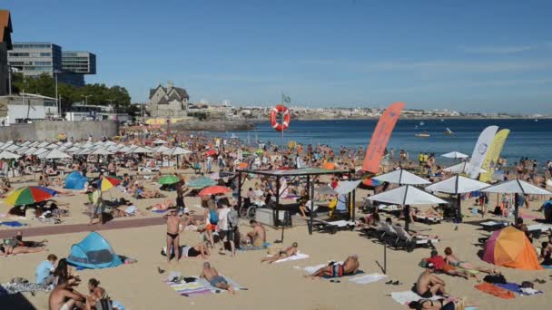 Praia de areia lotada em Cascais, perto de Lisboa, Portugal, durante o Verão. Esta praia é conhecida como Praia da Conceicao — Vídeo de Stock