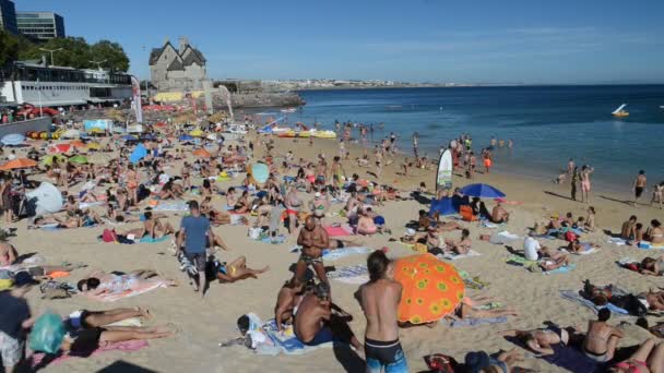 Plage de sable bondée à Cascais près de Lisbonne, Portugal pendant l'été. Cette plage est connue comme Praia da Conceicao. L'homme joue au jonglage — Video