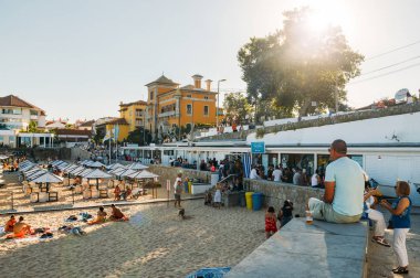 Yaz aylarında Lizbon yakınındaki Cascais içinde kalabalık kumlu plaj yanındaki tahta yol. Bu plaj Praia da Conceicao bilinir