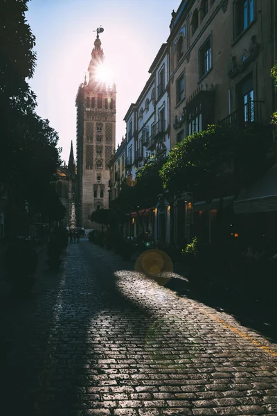 Dlážděné ulici s Seville Cathedral Gothic-maurské zvonicí Giralda, Sevilla, Španělsko — Stock fotografie