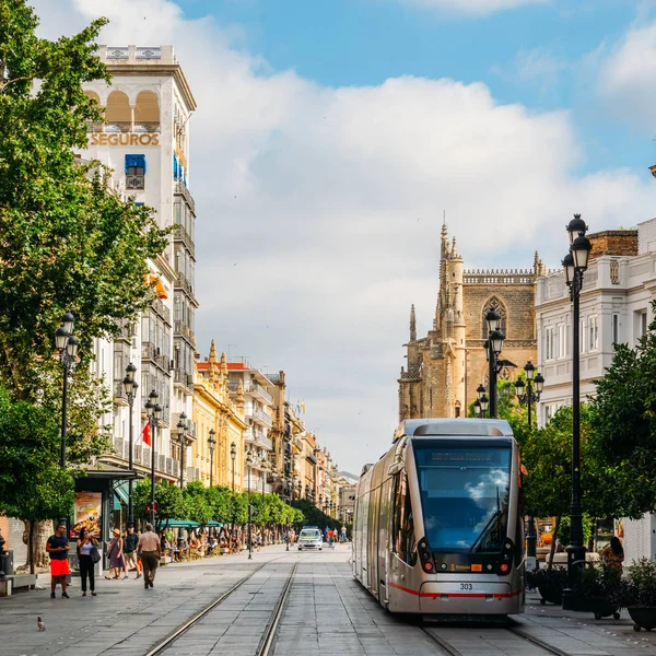 Electric tram on Constitution Avenue with iconic Seville Cathedral in background — Stock Photo, Image
