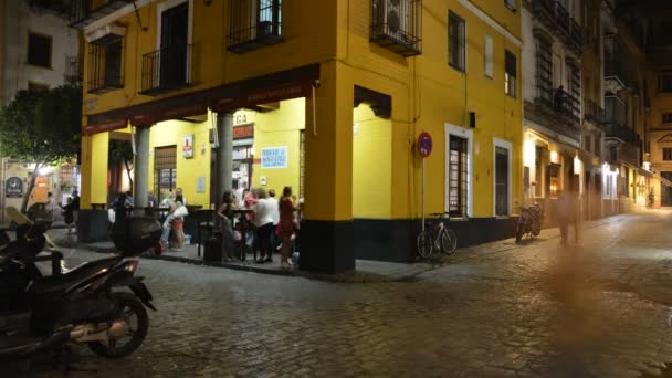 Zeitraffer im historischen Zentrum von Sevilla, wo Einheimische und Touristen bis in die späten Morgenstunden spanische Tapas serviert bekommen. Sevilla ist berühmt für sein lebhaftes Nachtleben — Stockvideo