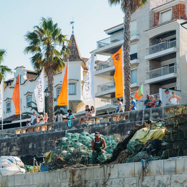 Cascais, Portekiz bir iskele bir iskelede balıkçılar demir parmaklıkları ve yeşil naylon ağlar, paslı balık tuzakları üzerinde çalışma yığılı