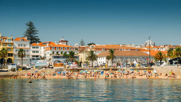 Толпившийся песчаный пляж в Кашкайше, недалеко от Лиссабона, Португалия, летом. Этот пляж известен как Прайя да Рибейра — стоковое фото