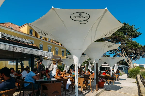 Los turistas disfrutan de una copa en un patio en un restaurante en la histórica Casa da Guia cerca de Cascais en una tarde soleada —  Fotos de Stock