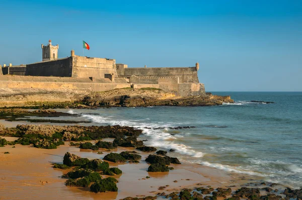 Waves crashing near the 16th Century Saint Julian Fortress at Carcavelos beach near Lisbon, Portugal Royalty Free Stock Images