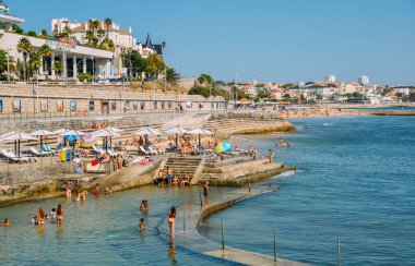 Aileler okyanus havuzu Alberto Romano Cascais içinde dinlenin. Kıyı şeridi Estoril arka planda görünür