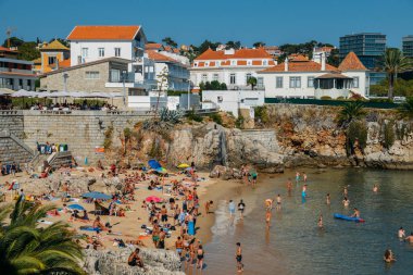 Cascais, Portekiz Praia da Rainha plajda güneşlenirken insanlar. Cascais ünlü ve popüler yaz tatili Portekizce ve yabancı turistler için spot olduğunu