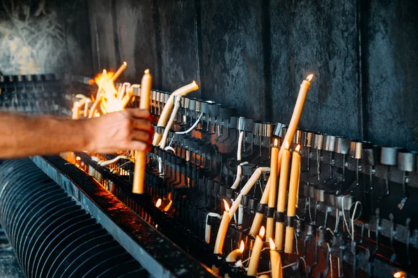 Persona non identificabile che accende una candela su un grande pezzo di cera — Foto Stock