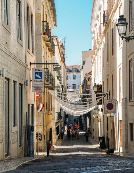 Rue étroite dans le centre historique de Lisbonne avec des rubans reliés aux balcons — Photo