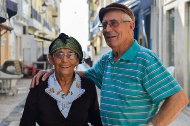 Geleneksel olarak yaşlı Portekizli kadın ve kocası Nazare, Portekiz bir Arnavut kaldırımlı sokakta giyinmiş