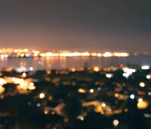 Avsiktligt suddig bokeh lampor på natten med waterscape — Stockfoto