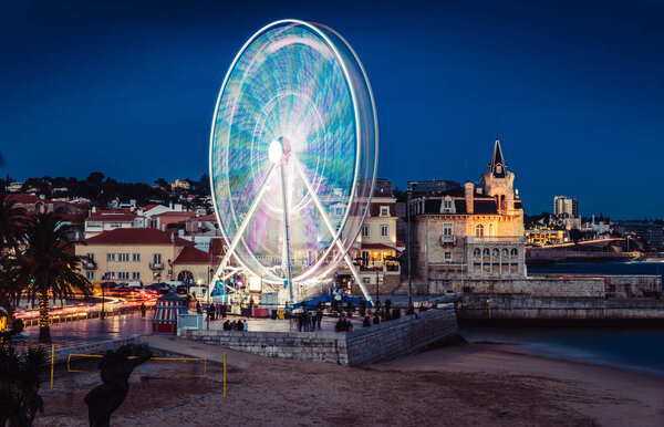 Long exposure of giant ferris wheel entertaining locals and tourists at Cascais, Portugal