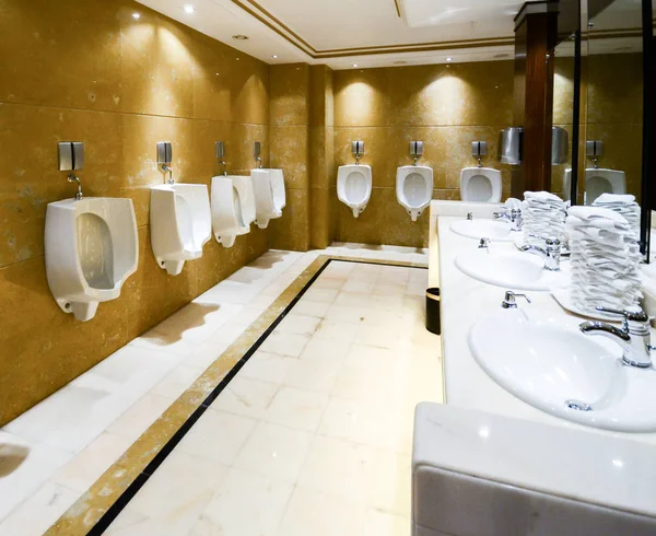 Eine Reihe von Urinalen in einer gefliesten Wand in einer öffentlichen Toilette — Stockfoto
