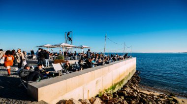İnsanlar Tagus Nehri bir güneşli kış gününde rahatla.