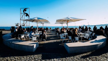 İnsanlar Tagus Nehri bir güneşli kış gününde rahatla.
