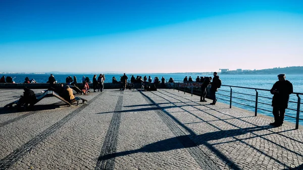 İnsanlar Tagus Nehri bir güneşli kış gününde rahatla.