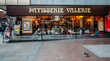 Diners through a window at Patisserie Valerie cafe in Hammersmith, London clipart