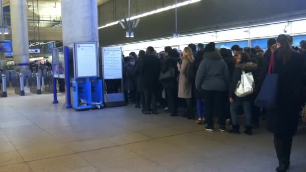 Γραφείο εργαζόμενος μετακινούνται στην εσπευσμένη ώρα ουρά να περάσει κλείστε εισιτήριο μηχανές εμπόδια στο μοντέρνας Canary Wharf του υπόγειου σιδηρόδρομου — Αρχείο Βίντεο