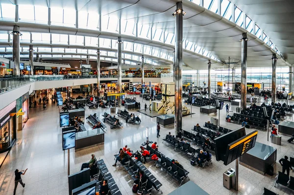 在英国伦敦希思罗机场3号航站楼候机楼的乘客和商店的高视角 — 图库照片