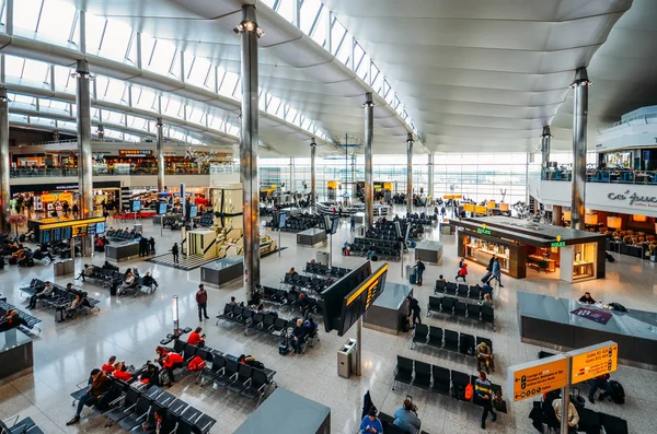 Υψηλή προοπτική άποψη των επιβατών και των καταστημάτων κατά την αναχώρηση τερματικού στο Heathrow Terminal 3 στο Λονδίνο, Ηνωμένο Βασίλειο — Φωτογραφία Αρχείου