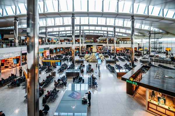 在英国伦敦希思罗机场3号航站楼候机楼的乘客和商店的高视角 — 图库照片