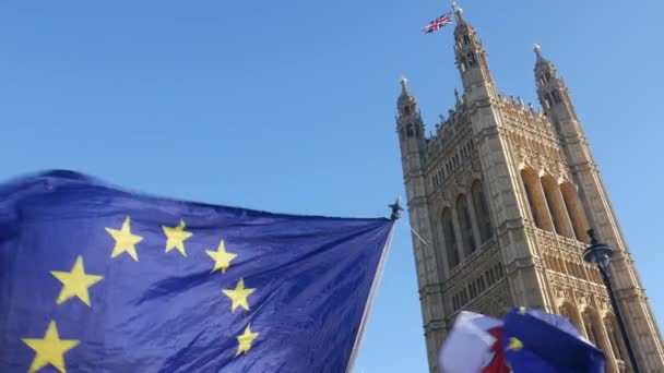 ウェストミン スター宮殿、ロンドン - Brexit テーマでビクトリア タワーの前で風になびかせて欧州連合 Eu と英国のフラグ — ストック動画