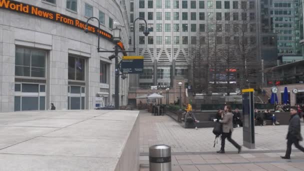 Kontorsanställda på lunchrast på Reuters Plaza i Londons Canary Wharf financial district — Stockvideo