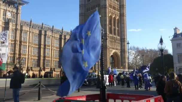 Aanhangers van de anti-Brexit Eu en Britse vlaggen zwaaien in de wind voor Westminster paleis — Stockvideo