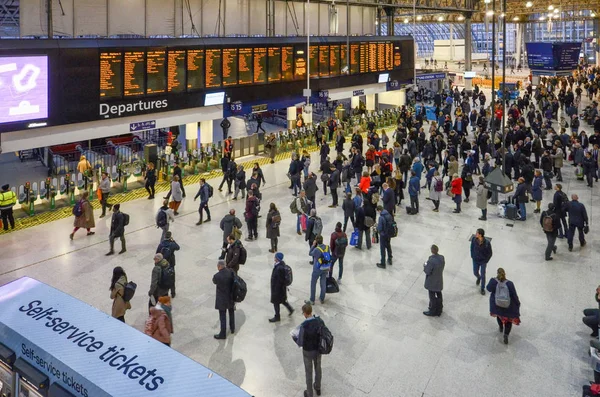 Muchas personas en frente de la tabla de tiempo en hora punta en la estación de tren de Waterloo, Londres, Inglaterra.Estación de Waterloo, una terminal ferroviaria del centro de Londres —  Fotos de Stock
