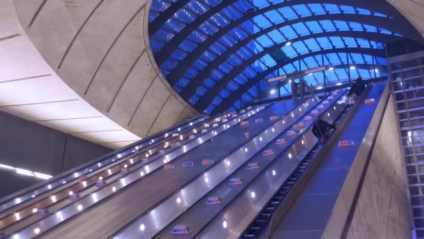 Looking up perspective of people going up escalator at Londons Canary Wharf Tube Station towards Reuters Plaza — Stock Video
