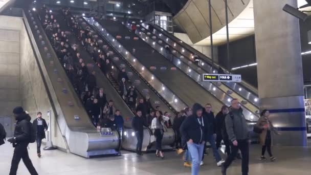 Los trabajadores de oficina viajan durante la hora punta subiendo y bajando escaleras mecánicas en London Docklands Canary Wharf Station — Vídeos de Stock
