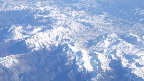 Vliegen over prachtige besneeuwde pieken uitzicht vanuit vliegtuig raam - 4k — Stockvideo