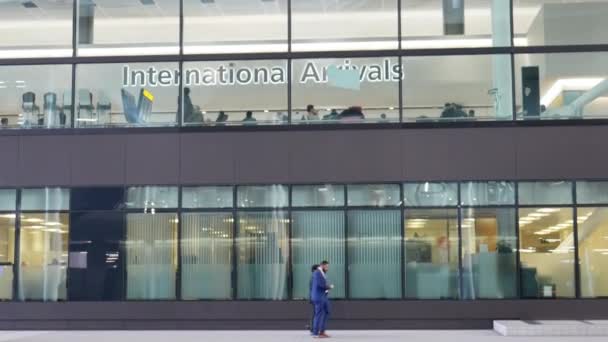 Menschen durch Glas bei der internationalen Ankunft im Terminal 2 des Heidekrautflughafens - dem Königinnenterminal — Stockvideo