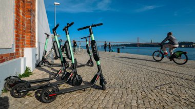 Dockless elektrikli scooter Tagus ve 25 bakan kıyısındaki Park paylaşılan Nisan Bridge uygulamasında Belem, Lisbon, Portekiz